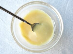 ガラス容器にはちみつ・マスタード・マヨネーズを入れ、スプーンで混ぜ合わせた様子