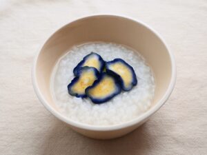 白粥になすの漬物をトッピングした様子