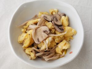きのこマリネと卵の炒めもの。マッシュルームの形と卵の黄色が映える