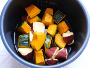 電気圧力鍋の内釜にかぼちゃとさつまいもを調味液ごと入れた状態