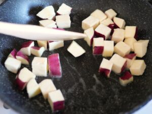 皮付きの角切りさつまいもを、フライパンでバター炒めにしている様子
