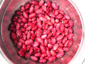 たっぷりの水に浸けた乾燥金時豆。浸水して皮のしわが少しずつ伸び、ふくらみ始めた様子