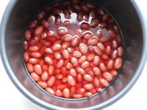 圧力調理が終わり、ふっくらとした金時豆。煮汁に浸して味をなじませているところ