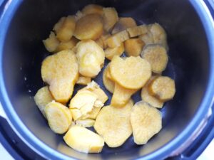 電気圧力鍋の内釜のゆで汁を捨てた状態。さつまいもが一部崩れている、やわらかな見た目