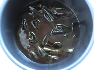 圧力調理後の電気圧力鍋の中の状態。煮汁に浸った結び昆布がつやよく煮えている