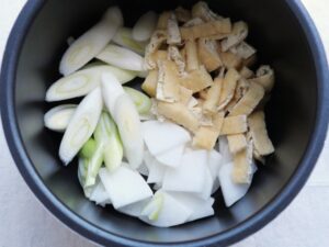 電気圧力鍋の内鍋に大根、長ねぎ、油揚げを入れた様子