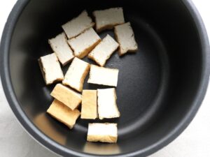電気圧力鍋に厚揚げを並べ入れた様子。加圧調理の下準備