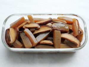 作り置き用の保存容器に詰められた、しいたけとこんにゃくの煮物。煮汁を切って入れた状態