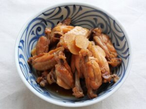 器に盛り付けた鶏手羽中の甘辛煮。甘辛ダレが絡んで照りよく、骨からほろっと外れるやわらかさ