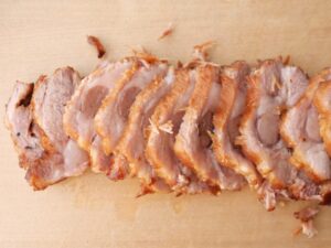 包丁でスライスした煮豚。脂身が入り、やわらかな見た目