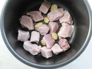 電気圧力鍋の内釜に豚肉と生姜の薄切りを入れたところ