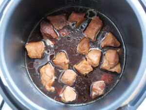 電気圧力鍋から、れんこんを取り出した後、豚肉をさらに煮詰めている様子