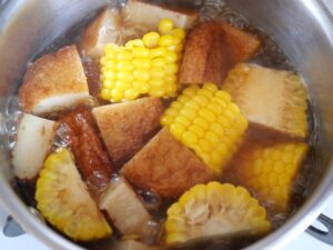 蒸しとうもろこしをさつまあげと一緒に鍋で煮て、煮物を作っているところ
