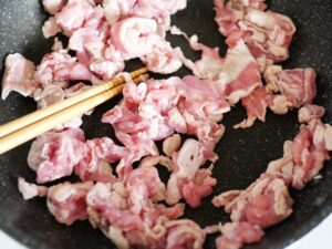 豚こま肉をほぐしながらフライパンで炒めているところ
