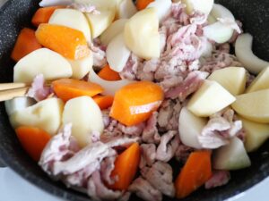 豚こま肉と人参・じゃがいも・玉ねぎをフライパンで炒めているところ