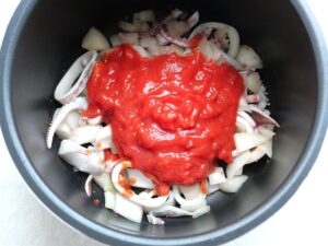 炒めたイカと玉ねぎの上にカットトマト缶を加えたところ