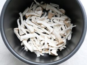 電気圧力鍋の内釜にほぐしたエリンギを並べ入れたところ