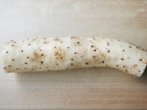 まな板に置いた皮つきの長芋。煮物用に下ごしらえする前の状態
