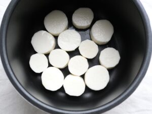 電気圧力鍋の内釜に輪切りの長芋を並べた加圧前の状態