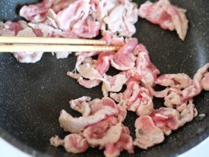 油を熱したフライパンで豚肉を炒めているところ