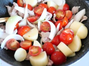 豚肉、ミニトマト、玉ねぎ、じゃがいもを炒めているところ（火を止めた直後）