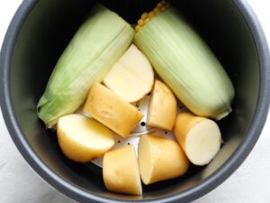 とうもろこしの隙間に、じゃがいもを皮を下にして並べ入れた状態（加圧直前の内釜の様子）