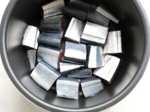 電気圧力鍋の内釜にさんまの切り身を並べ入れたところ。煮る直前の下準備