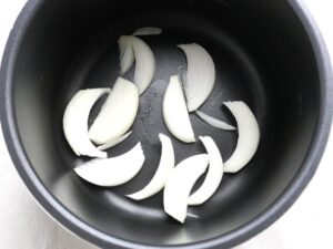 電気圧力鍋の内釜に玉ねぎを並べ入れたところ。圧力調理前の下準備