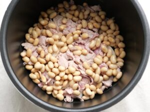 電気圧力鍋の内釜の豚肉の上から、大豆を加えた状態