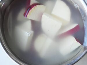 皮ごと輪切りまたは1/4切りにしたさつまいもを、水にさらしている様子