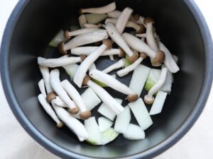 電気圧力鍋の内釜に玉ねぎとしめじを重ね入れた状態