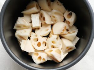電気圧力鍋の内釜に厚揚げとれんこんを重ねて並べた調理前の様子