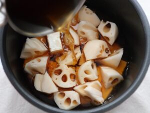 れんこんの上から煮汁を注ぐ工程
