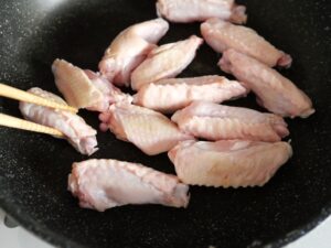 鶏手羽中をフライパンで下焼きして表面に火を通す工程