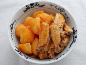 器に盛った鶏手羽中とじゃがいものケチャップ煮。やさしい赤味を帯びた、やわらかな仕上がり
