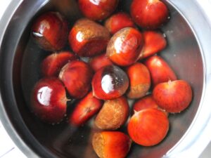 鬼皮付きの栗を熱湯に浸してやわらかくしている様子。電気圧力鍋でゆでる前の下ごしらえ工程