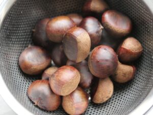 ざるに上げて水気を切った、ゆで栗。鬼皮にツヤのある仕上がり