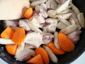 フライパンに鶏もも肉・ごぼう・人参を入れて軽く炒めているところ