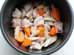電気圧力鍋に鶏もも肉・ごぼう・人参を入れたところ。圧力調理の準備工程