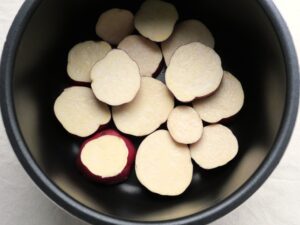 電気圧力鍋の内釜にさつまいもを並べ入れたところ。圧力調理前の下準備