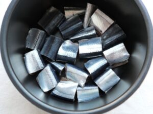 電気圧力鍋の内釜にさんまの切り身を並べ入れたところ。重ならないように釜底に詰めた状態