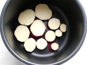 電気圧力鍋の内釜にさつまいもの輪切りを並べ入れた様子