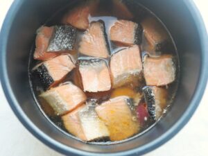 電気圧力鍋で圧力調理が終わり、やわらかく煮えた塩鮭とさつまいも