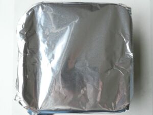 あさりと塩水を入れた容器にアルミホイルでふたをした状態