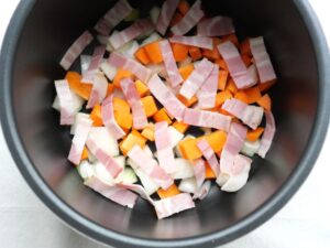 電気圧力鍋の内釜に玉ねぎ・人参・ベーコンを入れたところ