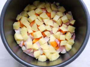 電気圧力鍋の内釜に、玉ねぎ・人参・ベーコン・じゃがいもを並べ入れたところ