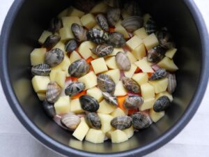 電気圧力鍋の内釜の具材の上に、あさりを並べ入れたところ