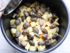 電気圧力鍋の内釜に水と酒の煮汁をまわしかけたところ。加圧前の状態