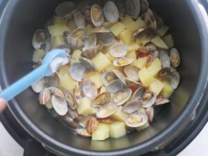 圧力調理後のクラムチャウダーの具材に塩を加えたところ。あさりが開き、じゃがいもがほくほくの蒸し上がり