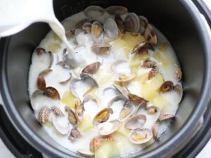 電気圧力鍋の内釜に牛乳を注いでいるところ